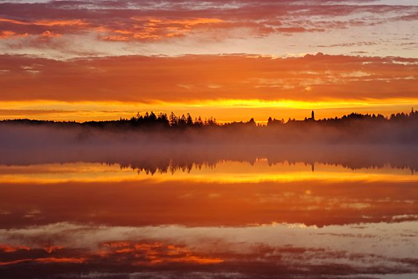 Germany, Bavaria, Upper Bavaria, Reutberg Abbey and lake Kirchsee in the morning