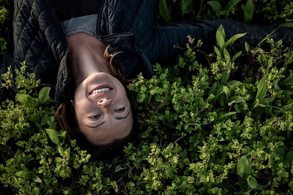Top view of happy woman lying in a field
