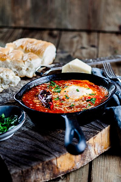 Eggs in Purgatory, eggs, baked in very spicy tomato sauce, sprinkled with parsley and parmegiano