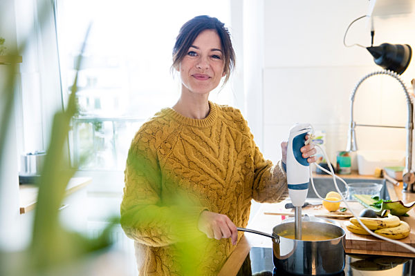 Woman preparing pumkin soup in her kitchen