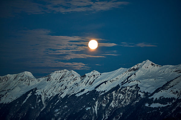 Switzerland, Bern, Hasliberg, moon over snowcapped mountains