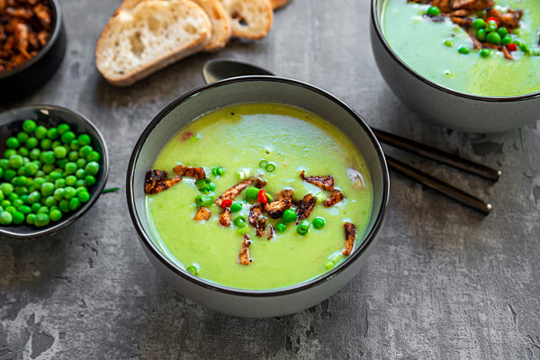 Bowls of pea soup with fried tofu, red chili pepper and spring onions