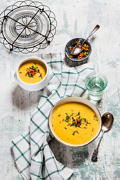 Bowls of vegan creamy carrot soup with coconut milk