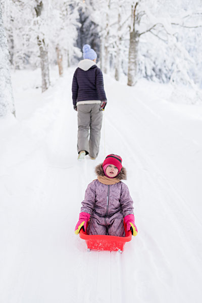Finland, Kuopio, mother and daugher sledging