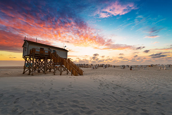 Germany, Sankt Peter Ording, pile dwellings on the beach in sunset