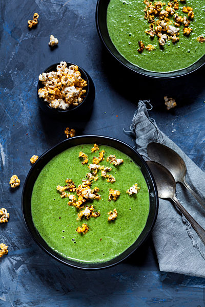 Vegan green vegetable soup with spinach, leek and peas, chili popcorn