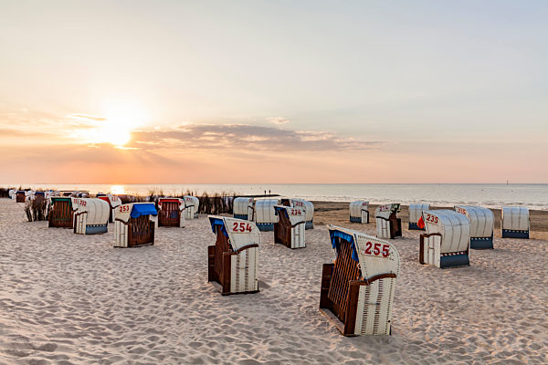 Germany, Lower Saxony, Cuxhaven, Duhnen, beach with hooded beach chairs at sunrise