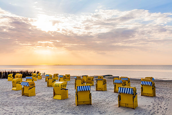 Germany, Lower Saxony, Cuxhaven, Duhnen, beach with hooded beach chairs at sunrise