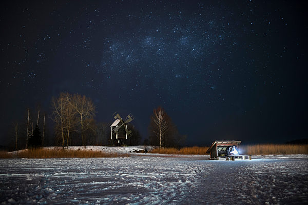 Finland, Kuopio, woman at campfire in winterat night