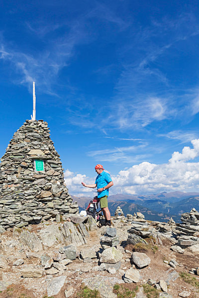 Hiker at viewpoint with cairn, Lammersdorf Mountain, Nock Mountains, Carinthia, Austria
