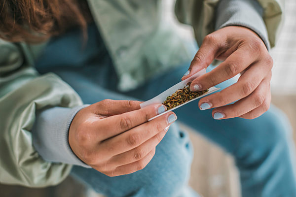 Woman's hands rolling a Marihuana joint, close-up
