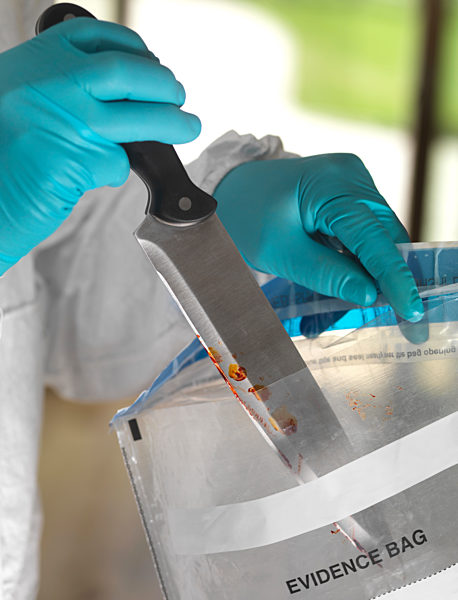 Forensic scientist bagging a knife taken from a violent crime scene