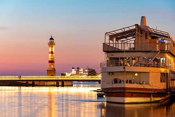 Ship moored in river against sky at dusk
