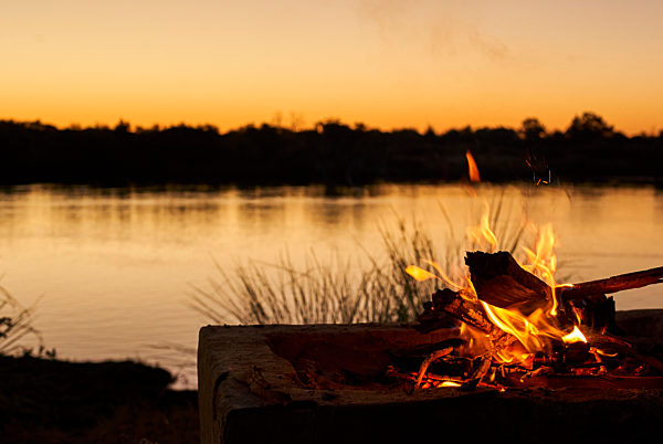 Bonfire at riverbank during sunset at Caprivi Strip, Namibia
