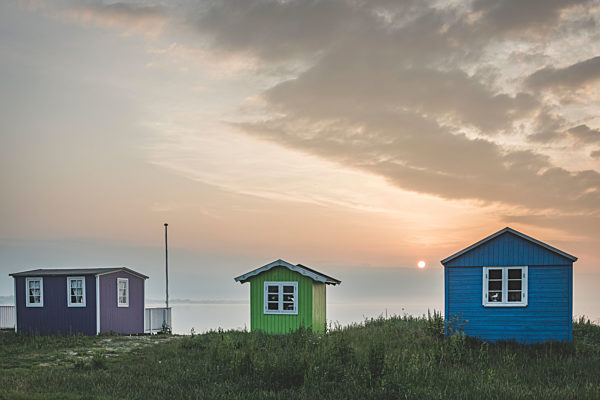 Denmark, Aeroe, Aeroskobing, Traditional baths on beach seen at sunset