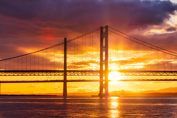 UK, Scotland, South Queensferry, Forth Road Bridge and Queensferry Crossing at dramatic sunset