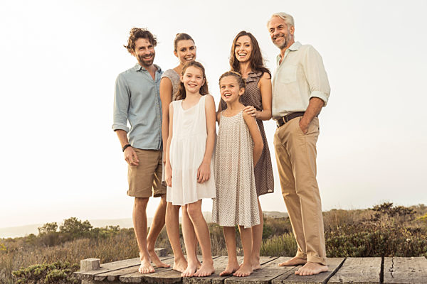 Large family enjoying the sunset standing on a boardwalk