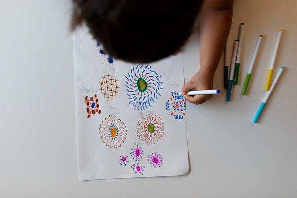 Crop view of little boy drawing flowers