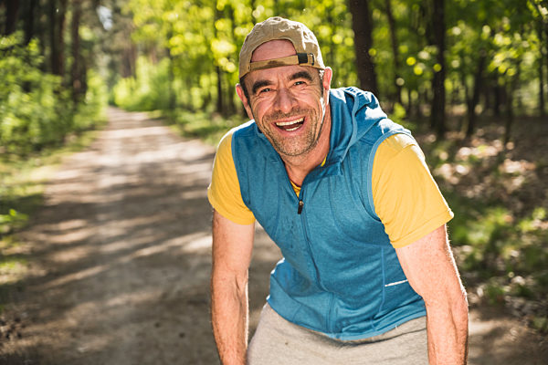 Happy mature man leaning at park