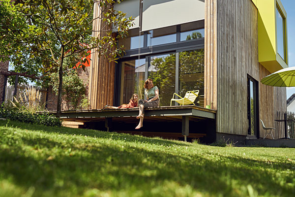 Mother and daughter relaxing outside tiny house in yard