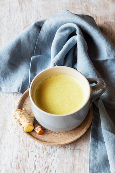 Turmeric milk with root kept by napkin on table