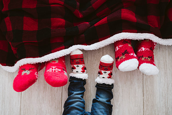 Parents and baby boy wearing Christmas socks at home during Christmas
