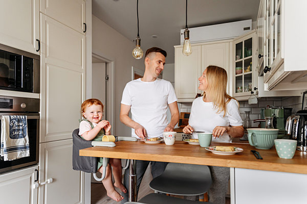 Happy family with baby daughter at kitchen table