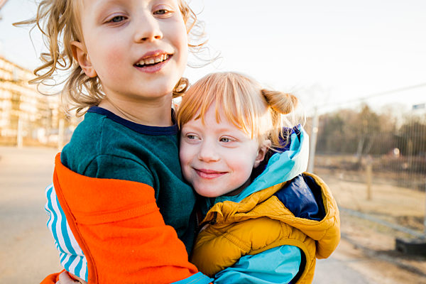 Smiling boy hugging cute sister