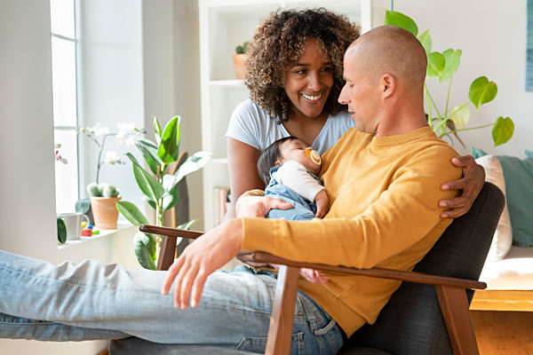 Mother and father with sleeping baby at home