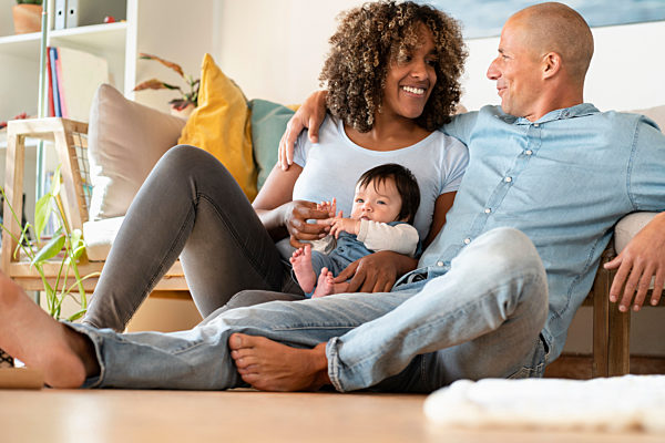 Happy family with daughter sitting on floor in living room