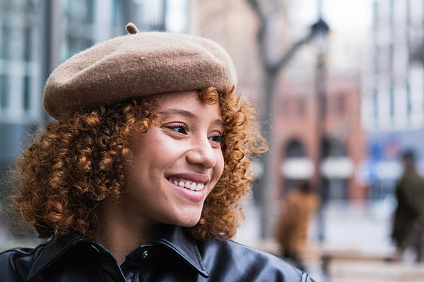 Smiling teenage girl wearing beret looking away while standing outdoors