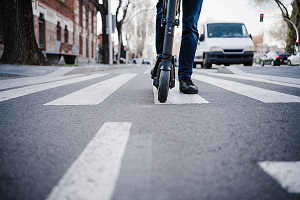 Man riding push scooter on road