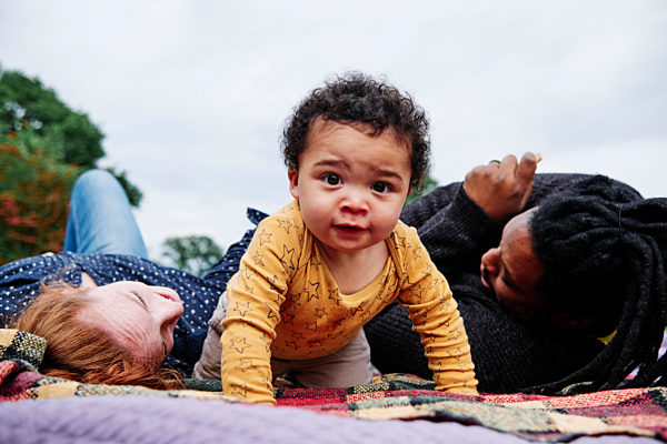 Carefree son crawling on picnic blanket at park