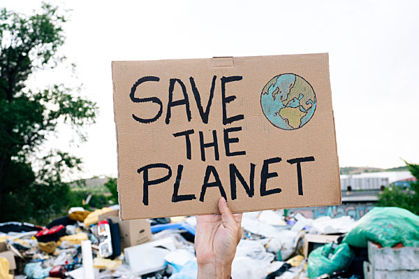Man holding save the planet text on cardboard