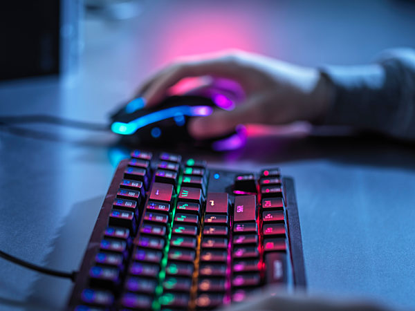 Boy playing game with gaming mouse and keyboard