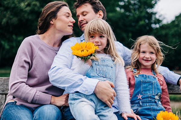 Family sitting together on bench at park