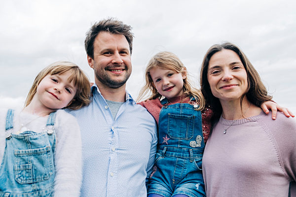 Smiling parents and daughters standing together
