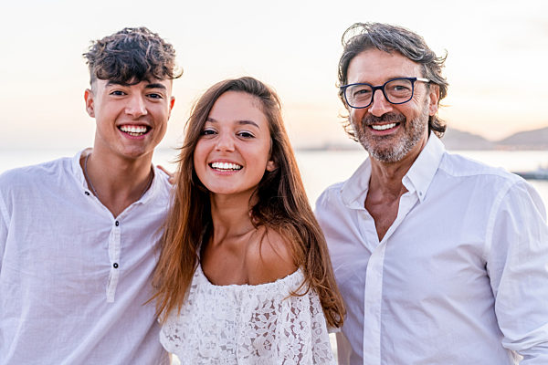 Beautiful woman standing with father and brother at beach