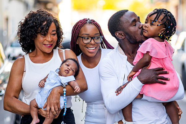 Young man kissing daughter by family
