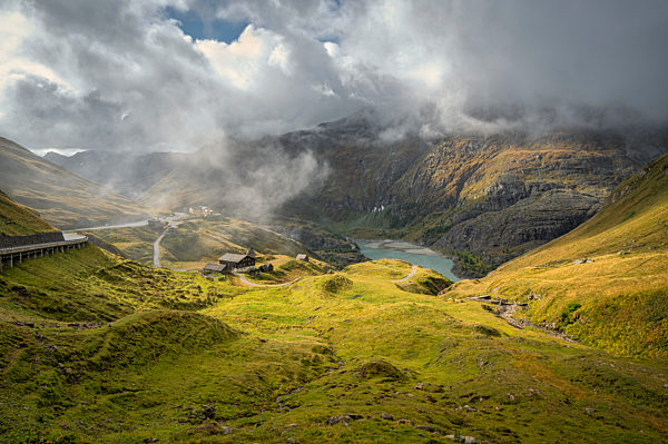 Low clouds over green valley and Grossglockner High Alpine Road in High Tauern National Park