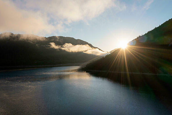 Drone view of Sylvenstein Reservoir at foggy autumn sunrise