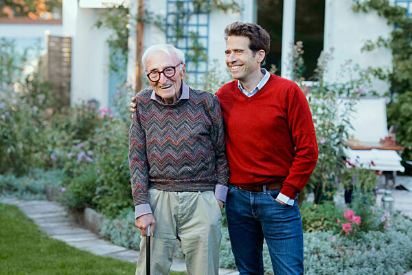 Happy man with father in backyard