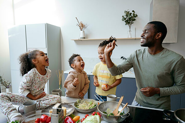 Man playing with family in kitchen