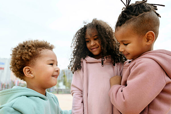 Smiling brother and sisters at sports field