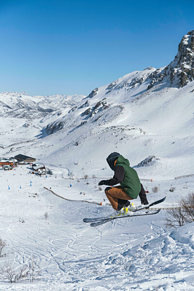 Young tourist in ski-wear skiing on snowcapped mountain
