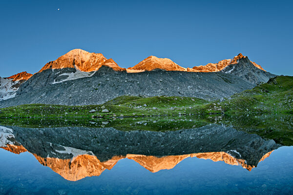 Konigspitze reflecting on surface of clear lake at dusk