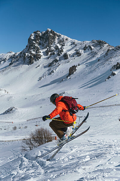 Tourist with backpack skiing on snowcapped mountain
