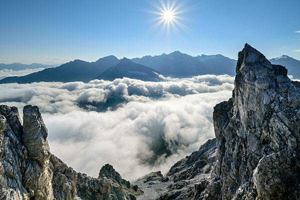 Sun rising over thick fog shrouding valley in Ortler Alps
