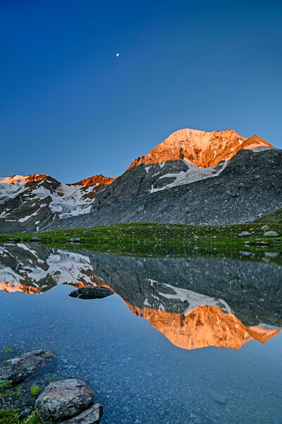 Konigspitze reflecting on surface of clear lake at dusk
