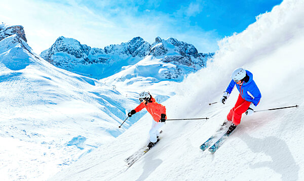 Man and woman skiing downhill on snowcapped mountain in Lech, Austria
